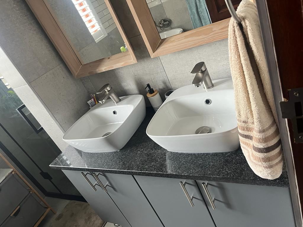 Double vessel basins on a granite countertop with mixer taps