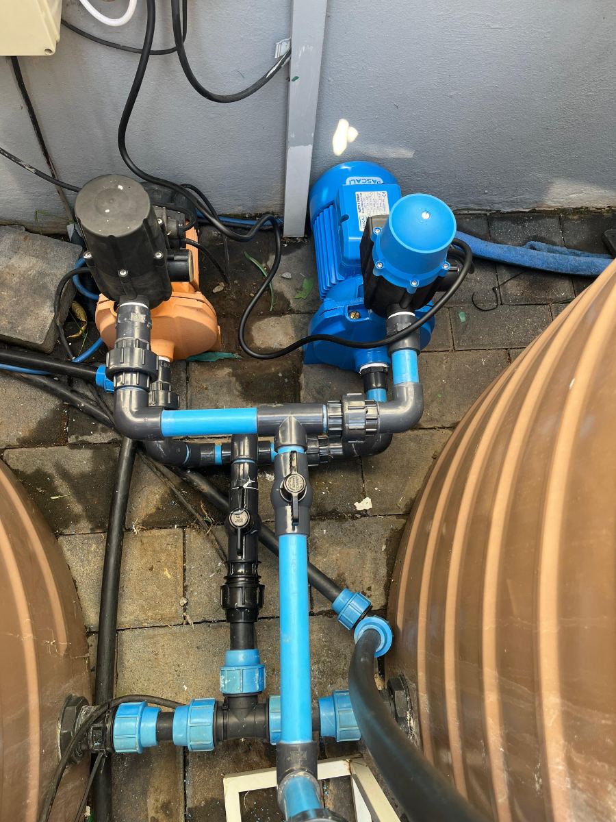Booster pump and valve manifold linking two domestic water tanks