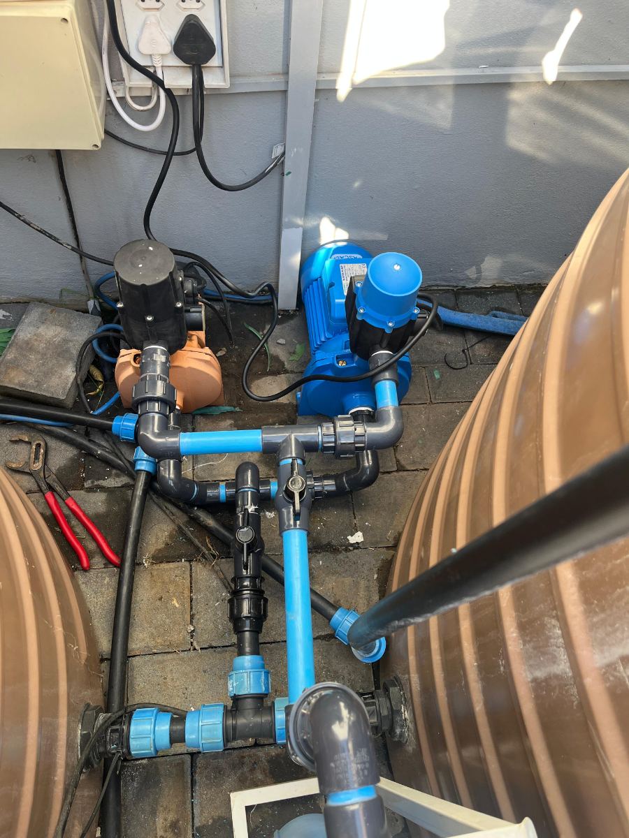 Twin booster pumps and PVC pipework manifold connecting domestic water tanks