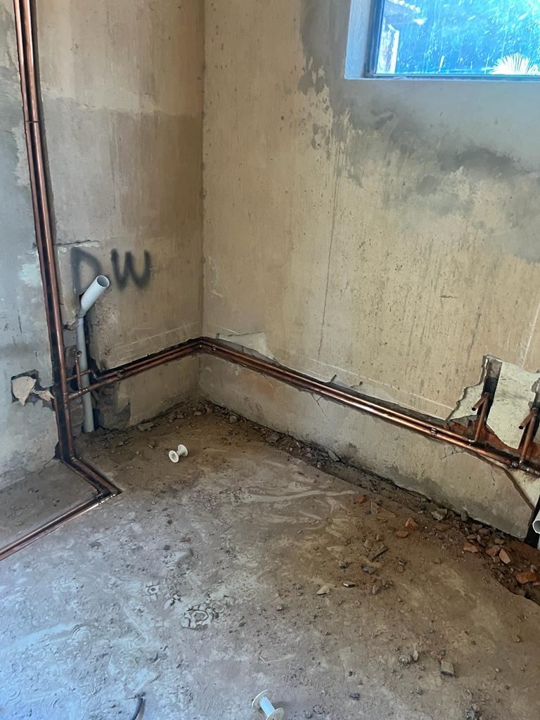 Copper supply lines routed around a room corner during renovation